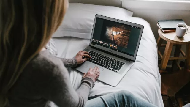 Mladá žena sleduje video na laptopu