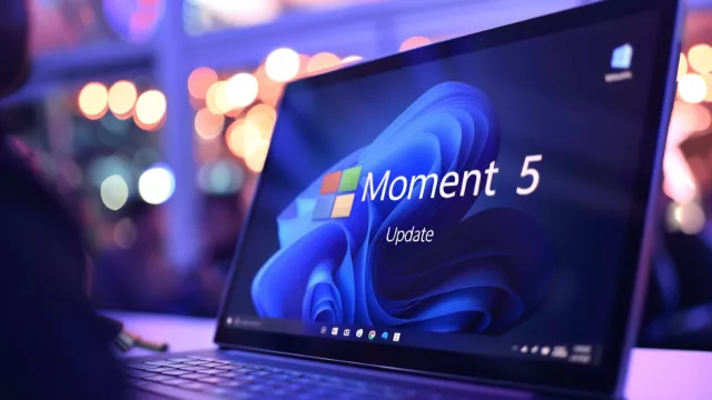 Laptop s Windows 11 a nápisem Moment 5 Update