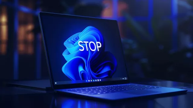 Laptop s Windows 11 a nápisem Stop