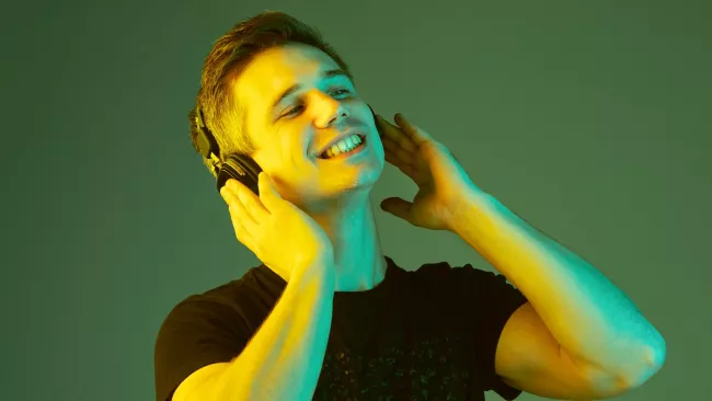 Muž poslouchá hudbu na zeleném pozadí