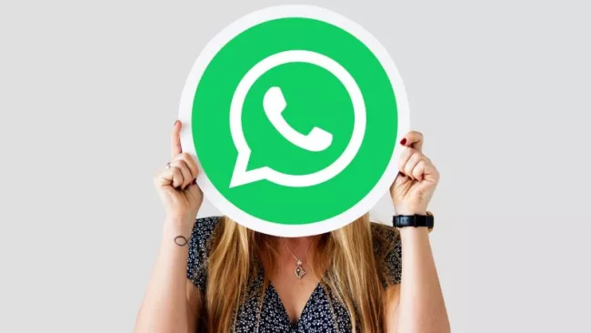 Žena si zakrývá obličej logem WhatsAppu