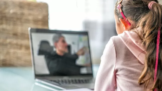 Dívka sleduje muže na obrazovce laptopu