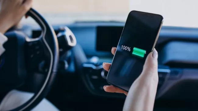 Žena v autě nabíjí smartphone