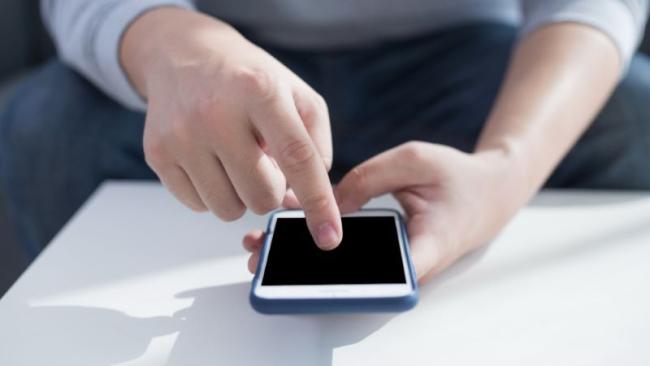 Uživatel ukazuje prstem na smartphone