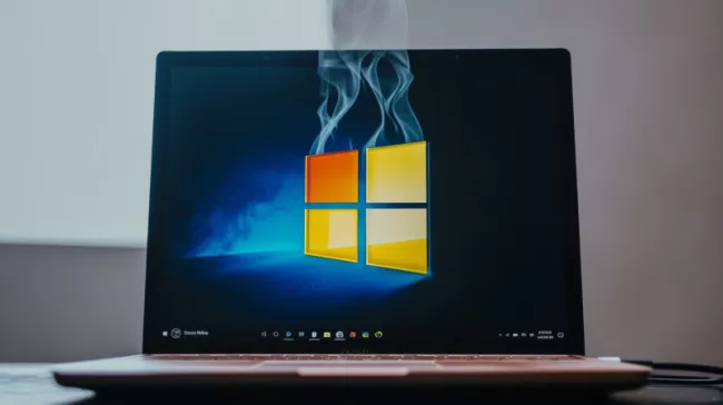 Logo Windows na displeji laptopu, z loga uniká kouř