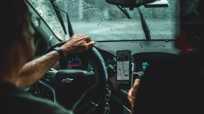 Řidič vozu manipuluje se smartphonem