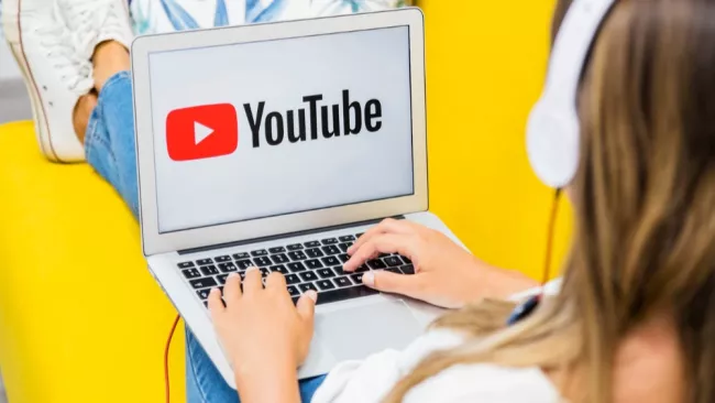 Dívka sleduje YouTube na notebooku