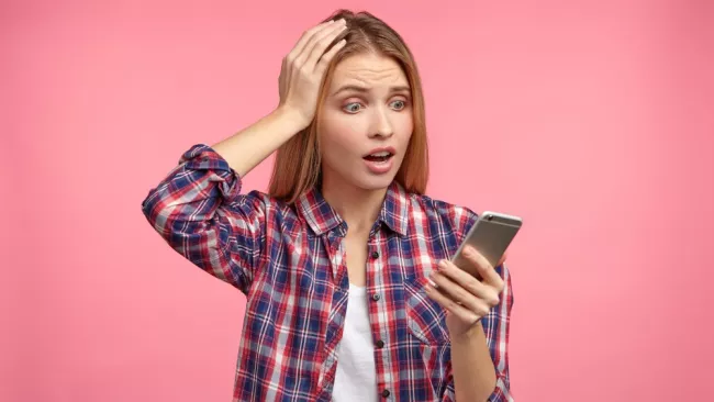 Mladá žena je zděšena z telefonu