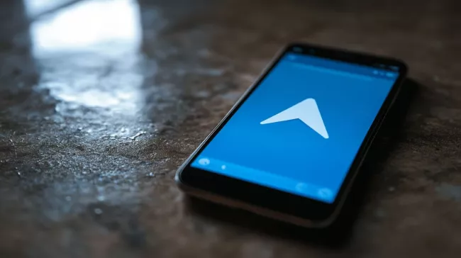 Logo Telegramu na displeji mobilu