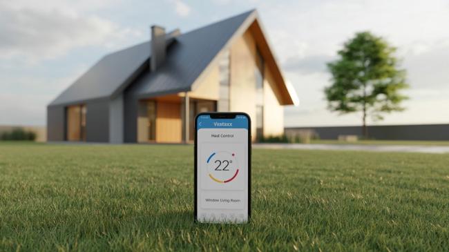 Moderní dům a smartphone s aplikací pro vytápění