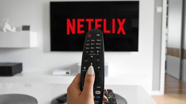 Uživatelka s dálkovým ovládáním a televizor s Netflixem