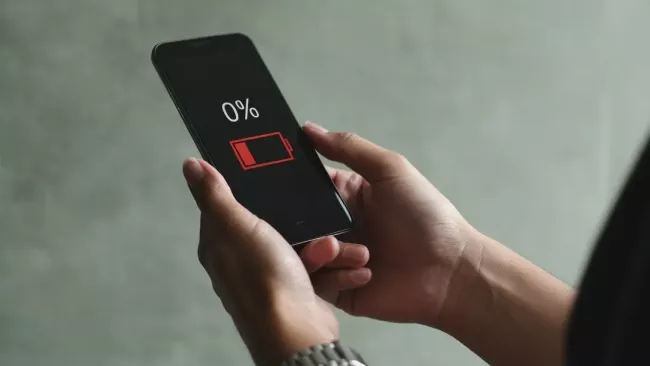 Uživatelka má v ruce vybitý telefon