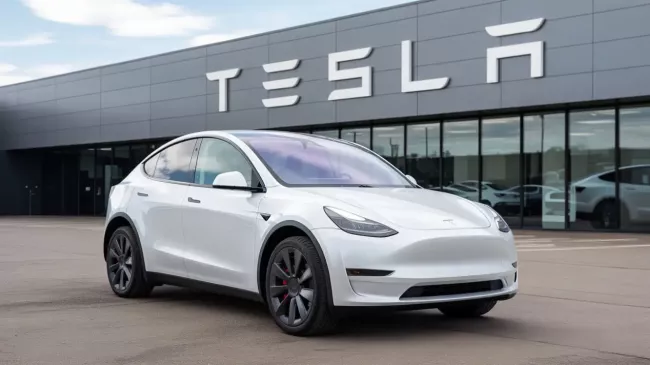 Bílý vůz Tesla před dealerstvím