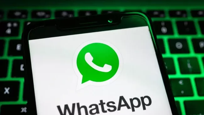Logo WhatsApp na displeji smartphonu, který leží na klávesnici