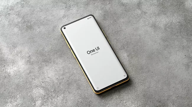 Moderní smartphone s textem One UI na displeji