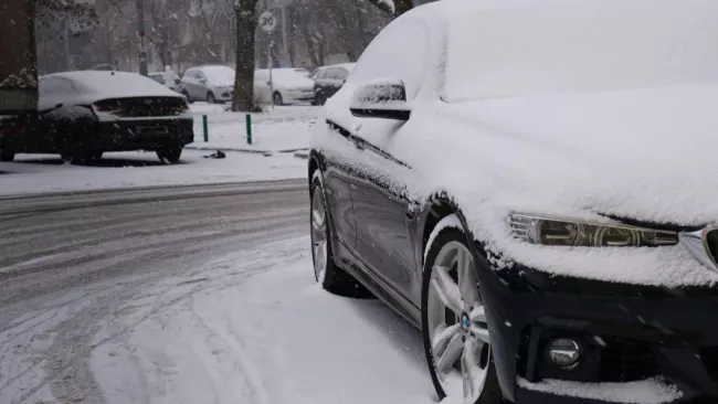 Parkující BMW zapadané sněhem