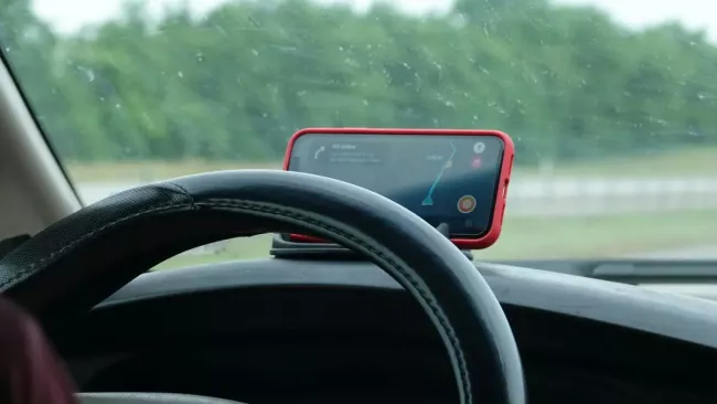 Smartphone na palubní desce vozidla slouží jako navigace