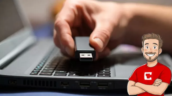 Uživatelka drží v prstech USB flash disk nad laptopem