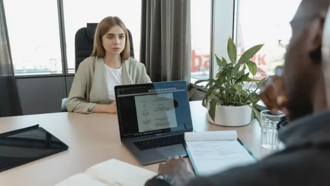 Vystrašená dívka jedná s mužem, který má laptop