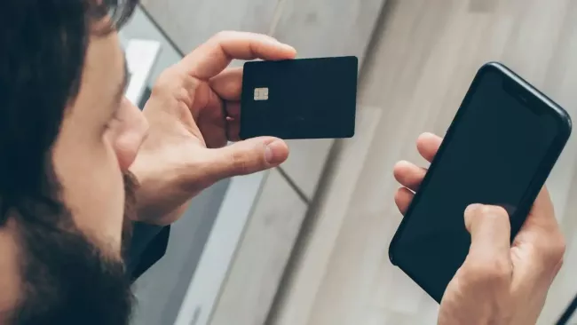 Uživatel má v rukou smartphone a platební kartu