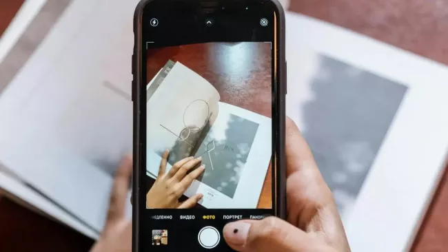 Uživatelka skenuje knihu pomocí mobilu