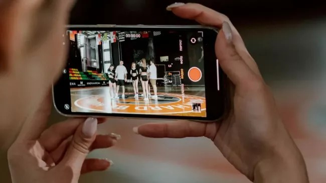 Uživatelka sleduje gymnastiku na mobilu