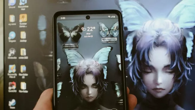 Displej mobilního telefonu a v pozadí podobný obraz na monitoru