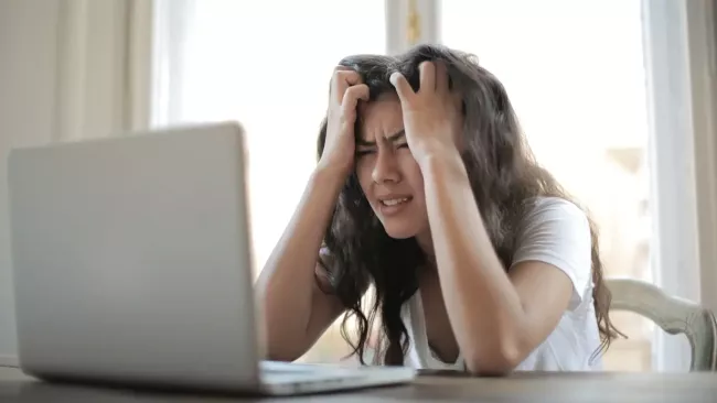 Naštvaně působící uživatelka u svého laptopu