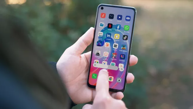 Uživatel drží prst na displeji svého mobilu