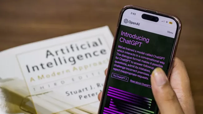 ChatGPT na displeji smartphonu a v pozadí na displeji laptopu