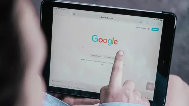Uživatel ukazuje prstem na prohlížeč Chrome na svém tabletu
