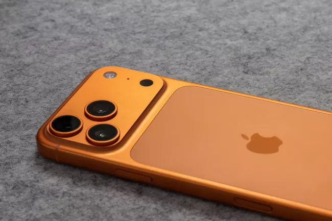 Oranžový Iphone 17 na šedém podkladu.