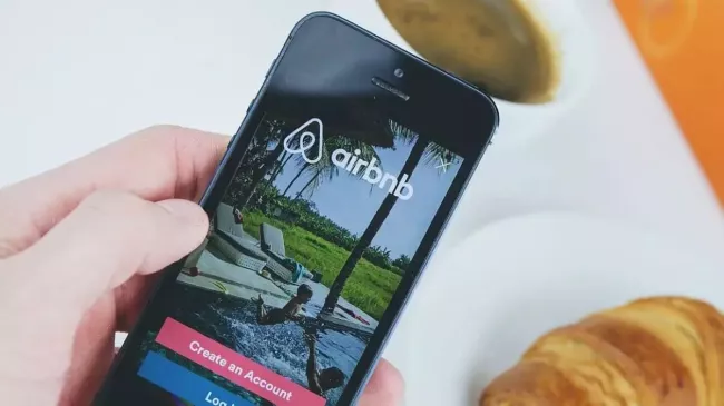 Symbolika služby Airbnb na displeji mobilu