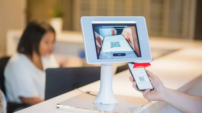 Uživatel přikládá svůj QR kód ke čtečce