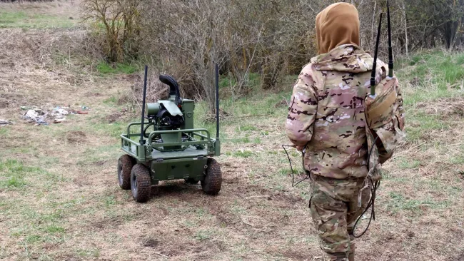 Voják testuje pozemní dron v terénu.