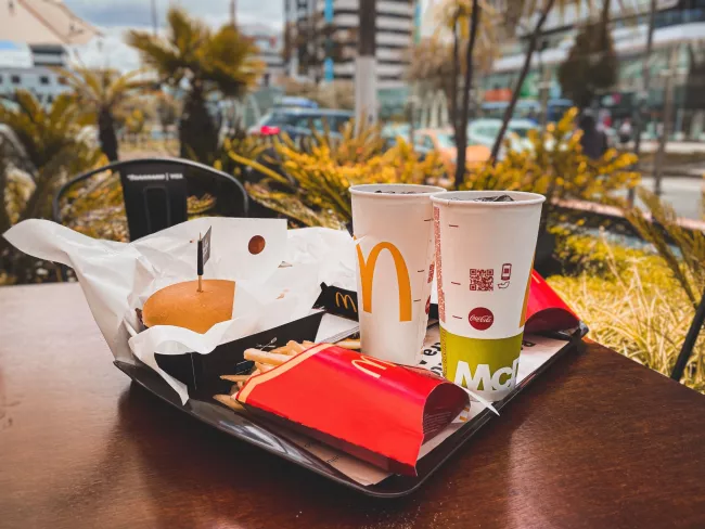 Burger, hranolky a nápoj z McDonald's.