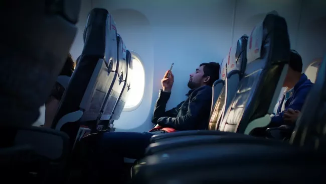 Uživatel sleduje smartphone na palubě letadla