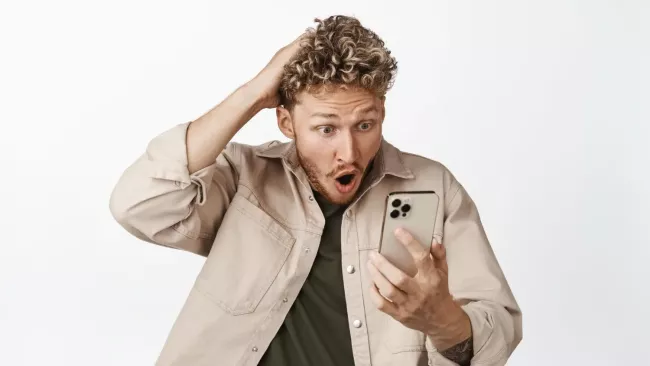 Šokovaný uživatel s iPhonem v ruce