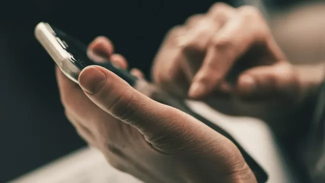 Uživatel ovládá smartphone rukou