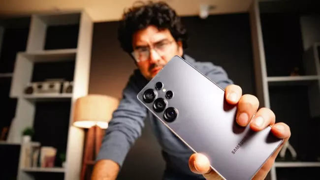 Uživatel ukazuje na kameru smartphone Samsung Galaxy