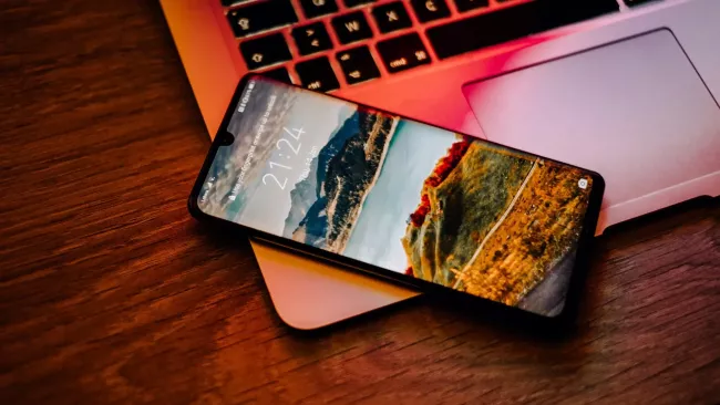 Smartphone položený na klávesnici laptopu