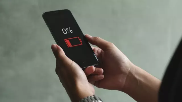 Uživatelka má v ruce vybitý telefon