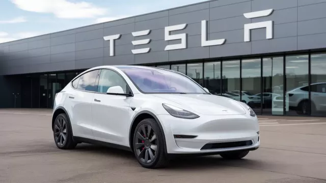 Bílý vůz Tesla před dealerstvím