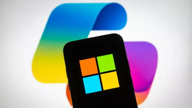 Logo Windows na displeji mobilu a v pozadí logo Copilotu