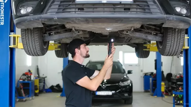 Automechanik opravuje vozidlo na heveru
