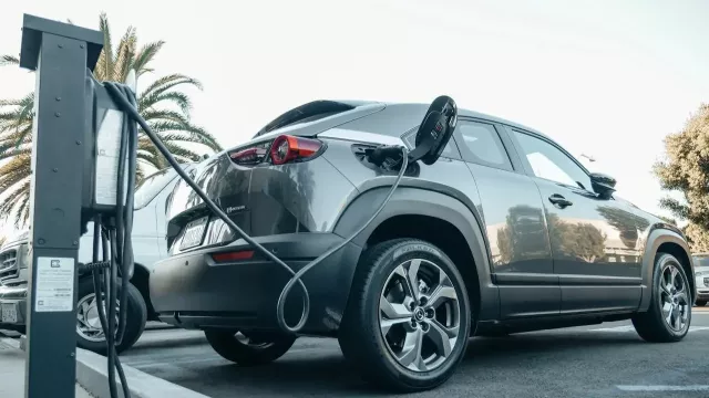 Šedé SUV na dobíjecí stanici