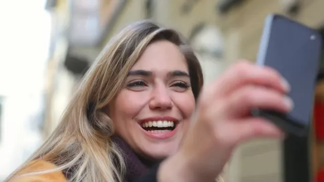 Šťastná uživatelka se fotí novým mobilem