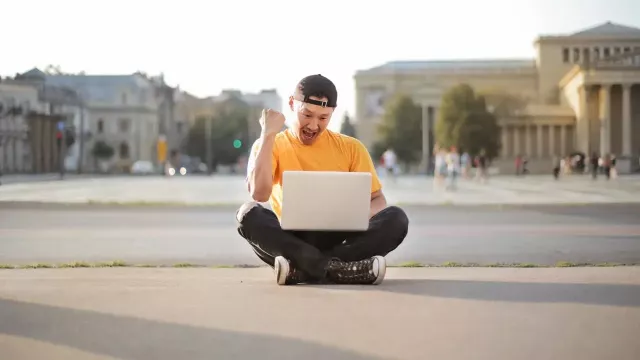 Šťastný uživatel laptopu, kterému se něco povedlo