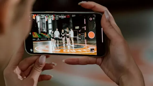 Uživatelka sleduje gymnastiku na mobilu