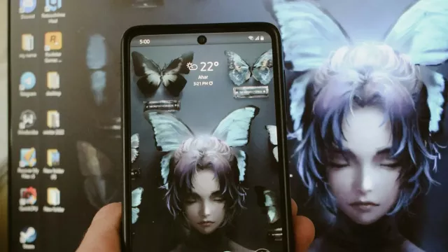 Displej mobilního telefonu a v pozadí podobný obraz na monitoru